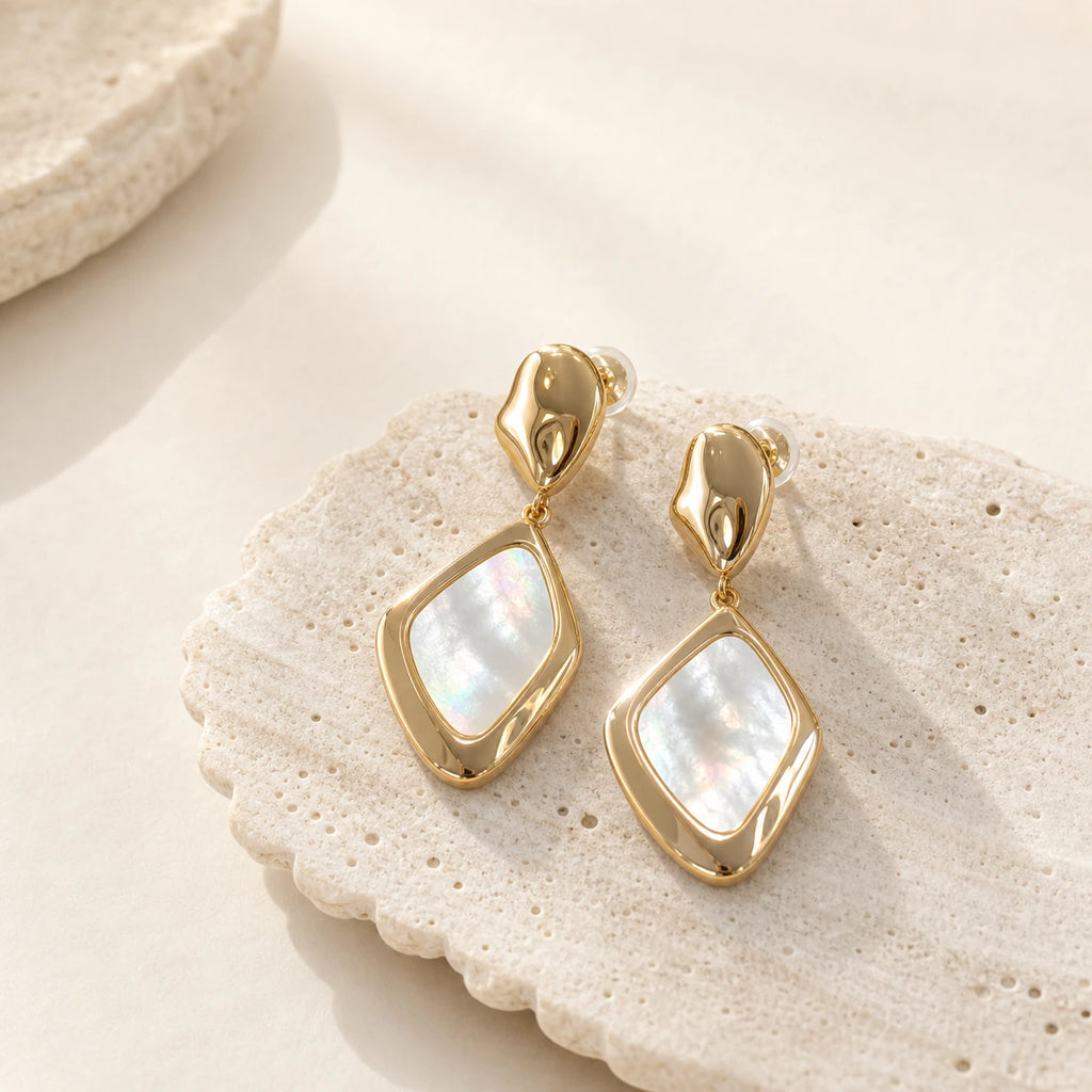 Square Mother-of-Pearl Drop Earrings in Gold-plated brass with 925 sterling silver posts displayed on a shell-textured plate.