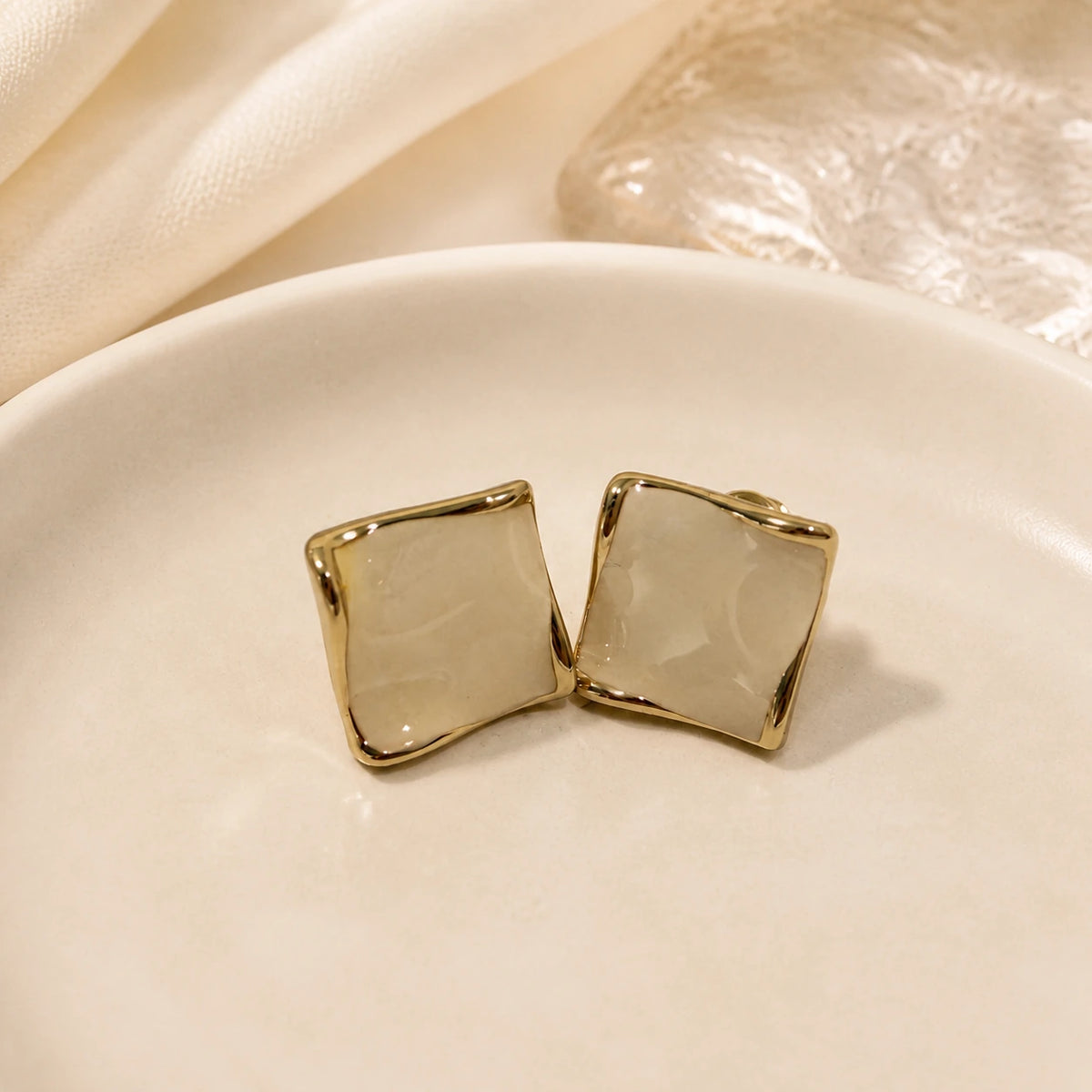 Cream square stud earrings in gold close-up with side and front detail