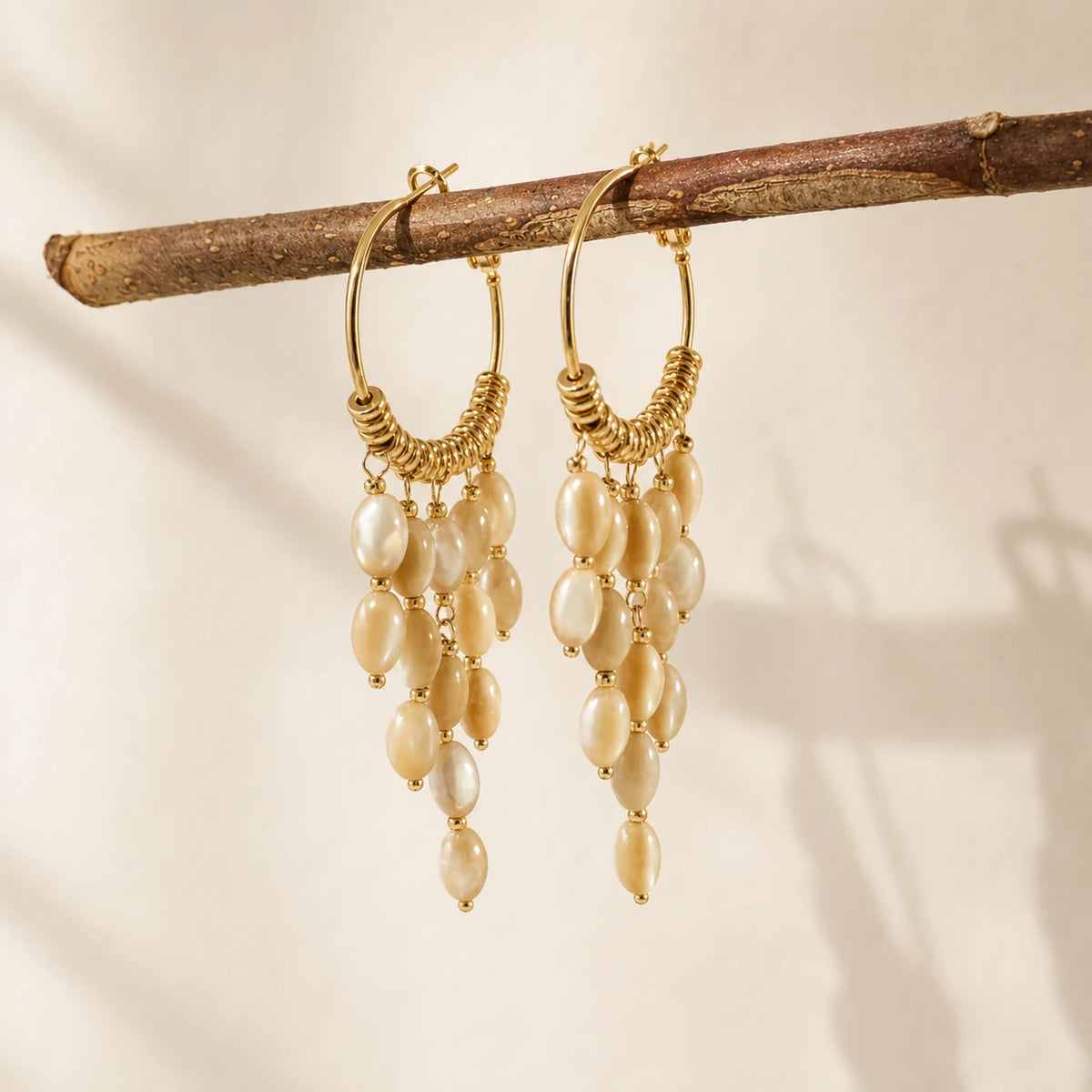 Bohemian pearl tassel drop earrings in gold hanging on branch