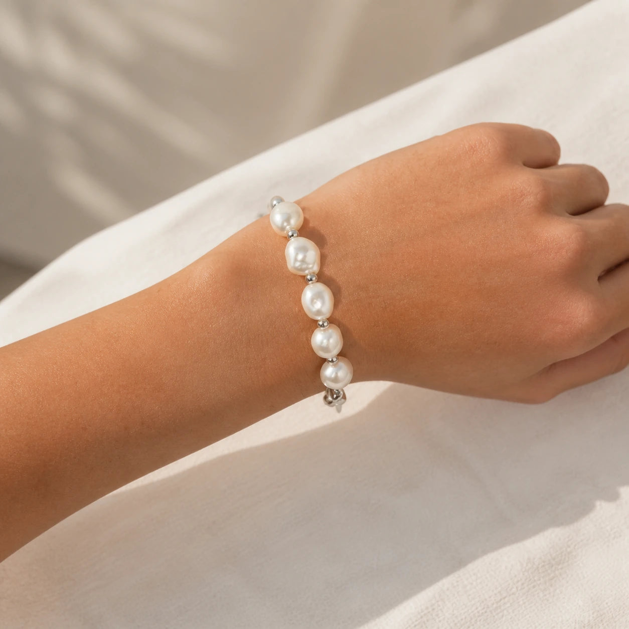 Silver baroque freshwater pearl bracelet worn close-up