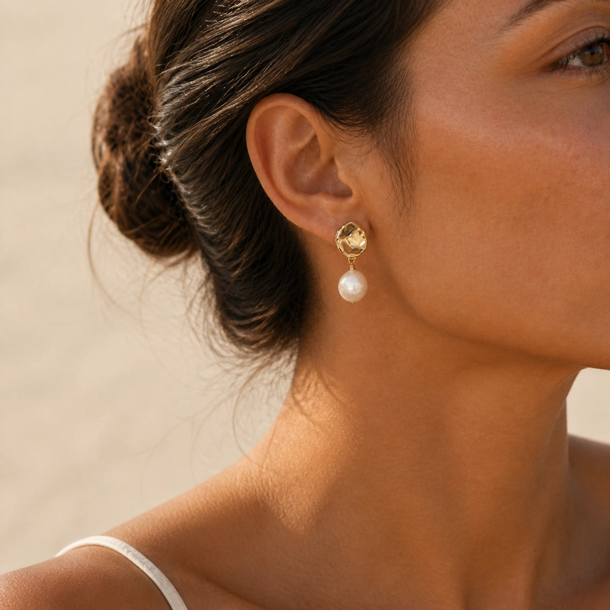 Petite baroque pearl drop earrings in gold model wearing close-up