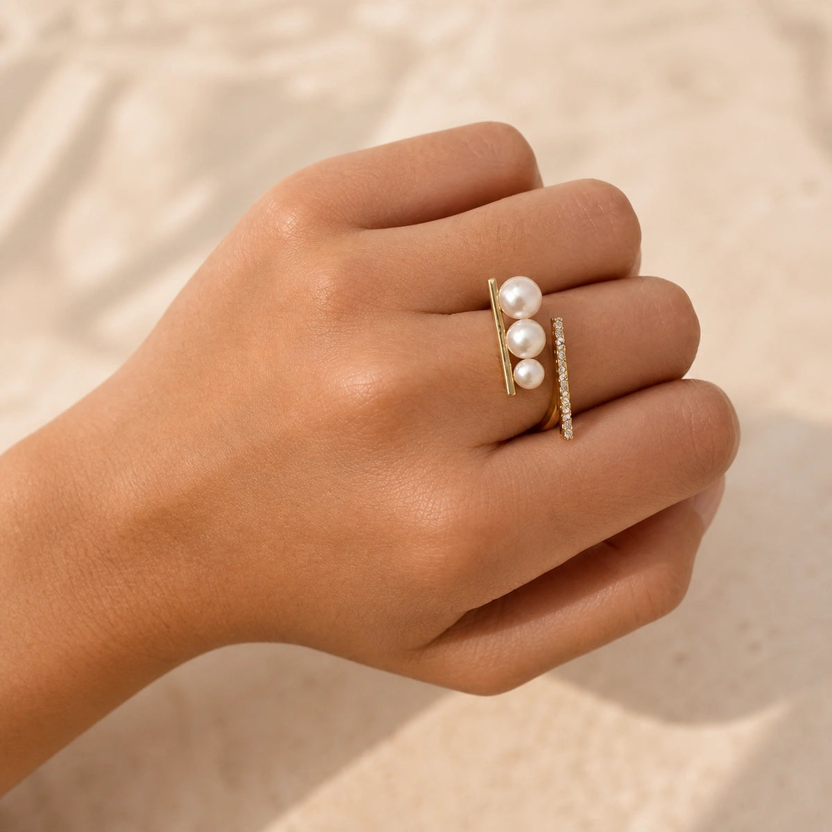 French triple pearl ring in gold worn close-up with pearl and crystal detail