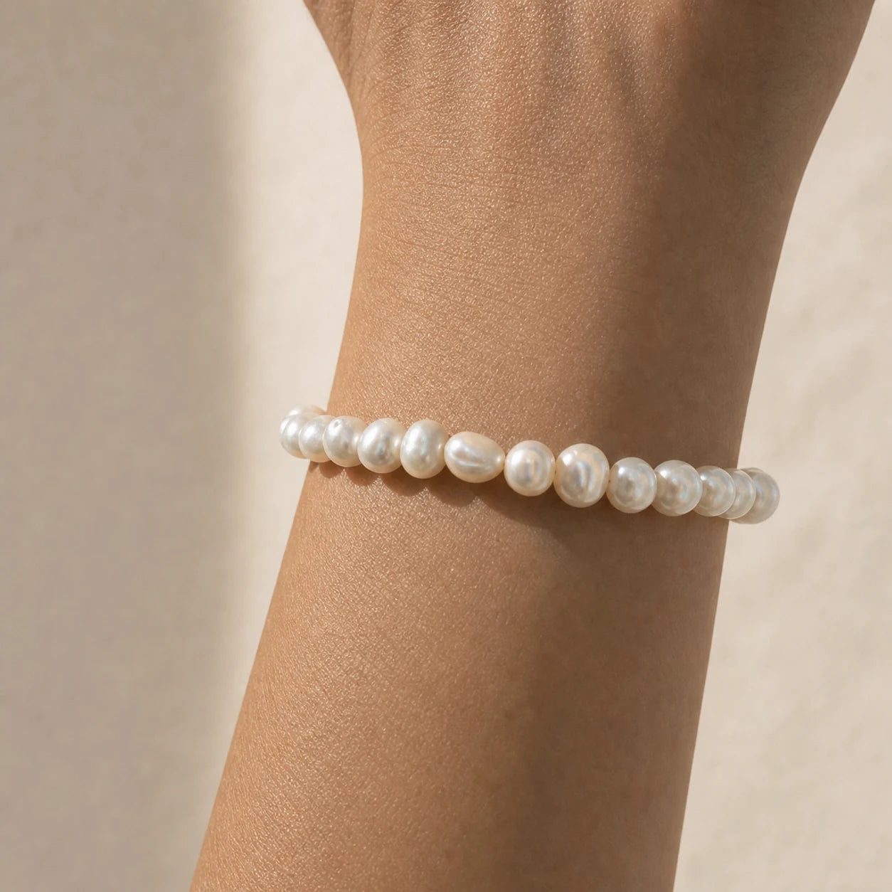 Close-up of white baroque freshwater pearl bracelet worn on wrist