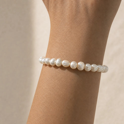 Close-up of white baroque freshwater pearl bracelet worn on wrist