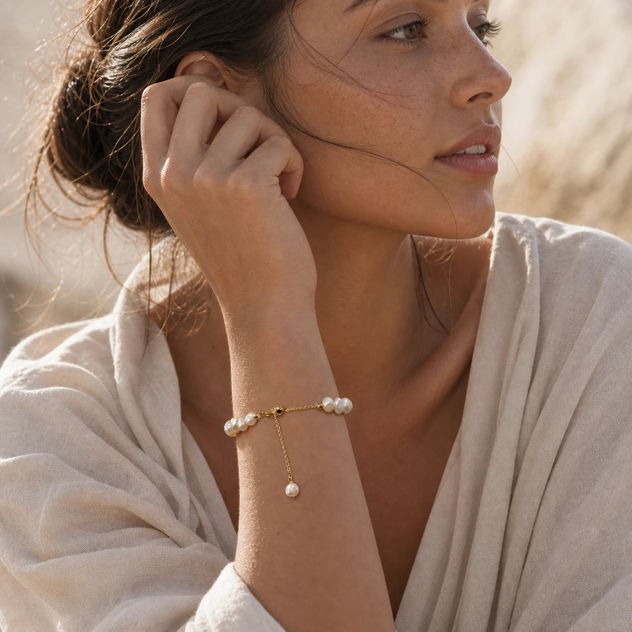 Model wearing a baroque freshwater pearl bracelet with gold extension chain