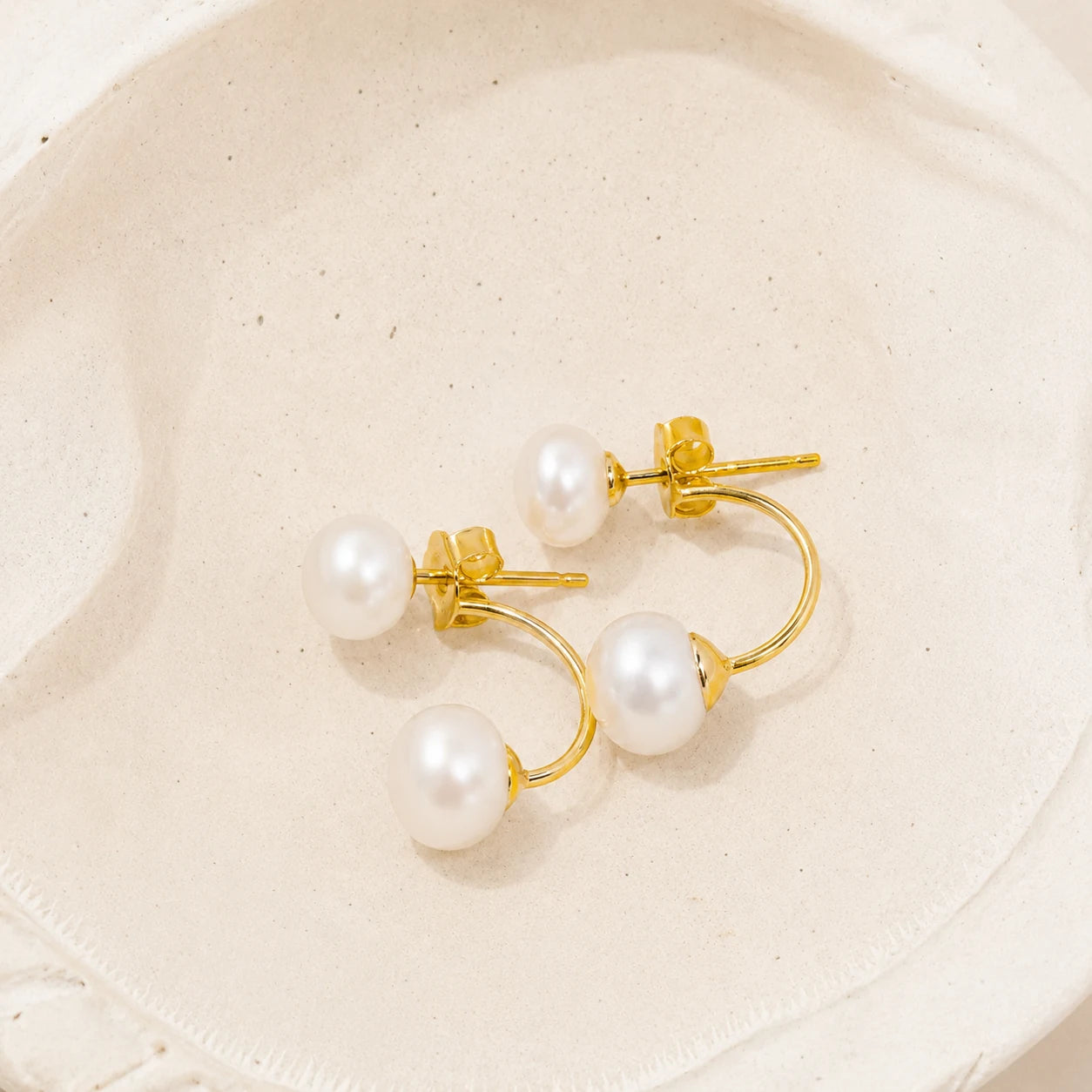 Double Pearl Jacket Earrings in Gold-plated 925 sterling silver displayed in a product styling scene.