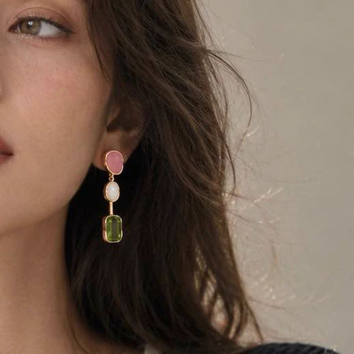 Close-up of green stone drop earrings in Gold-plated brass with 925 sterling silver hooks.