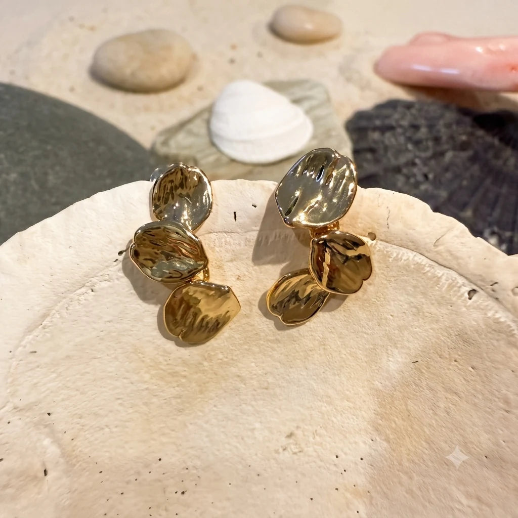 Close-up of leaf earrings in Gold-plated brass with 925 sterling silver hooks.