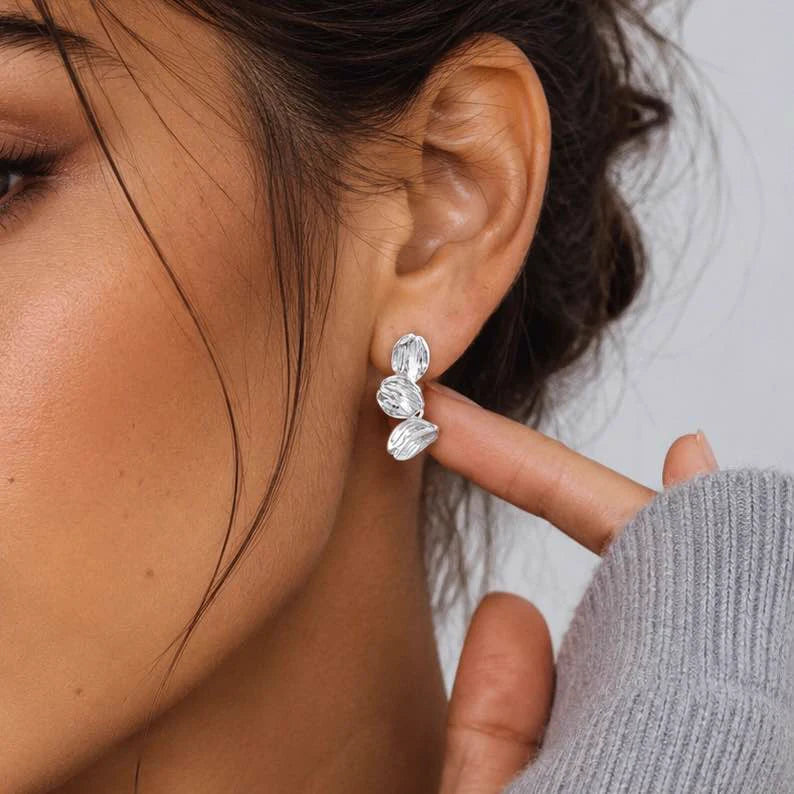 Close-up of leaf earrings in Rhodium-plated brass with 925 sterling silver posts.