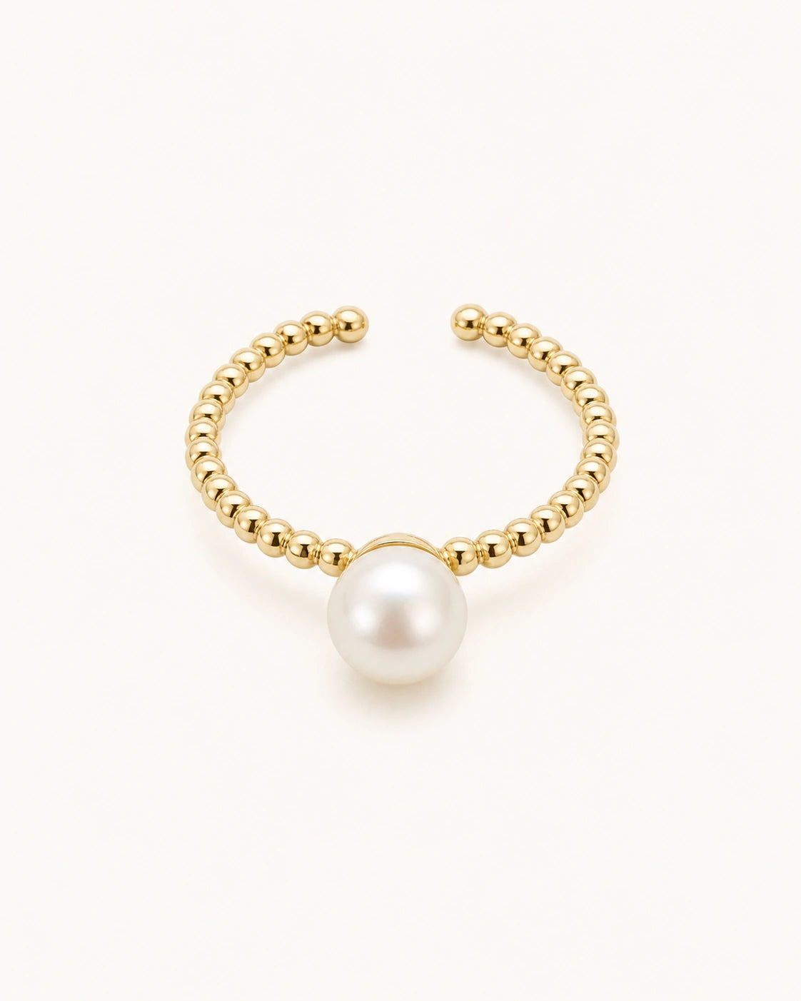 Minimal pearl ring in gold on clean white background