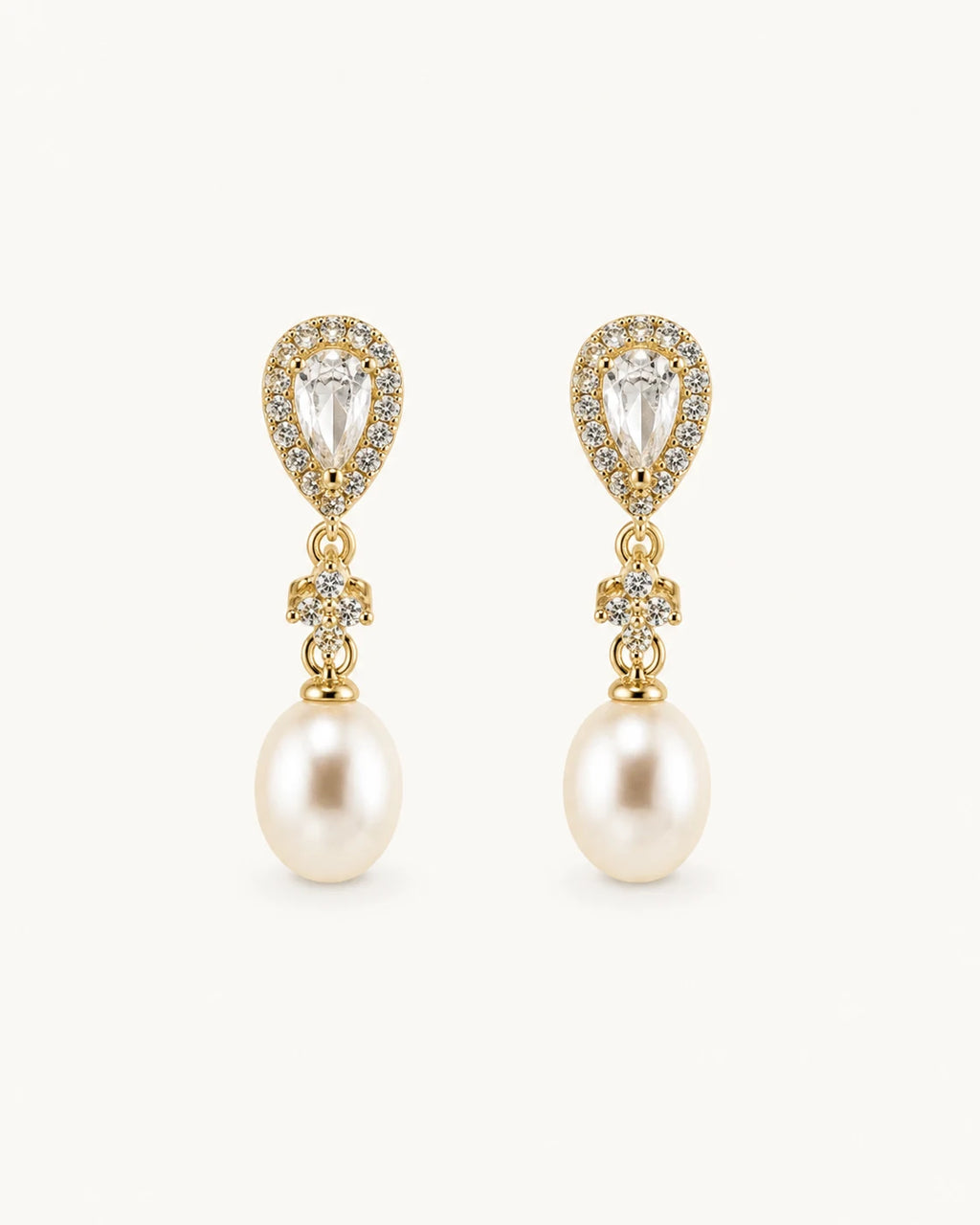 Crystal pearl teardrop earrings in gold on clean white background