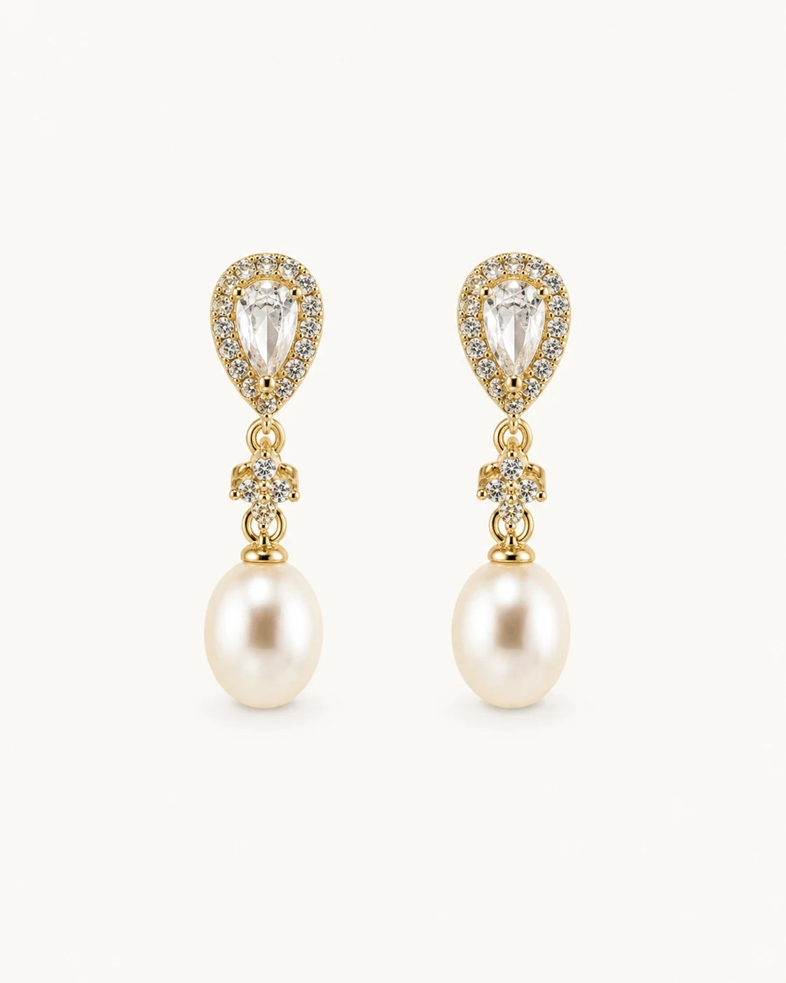 Crystal pearl teardrop earrings in gold on clean white background
