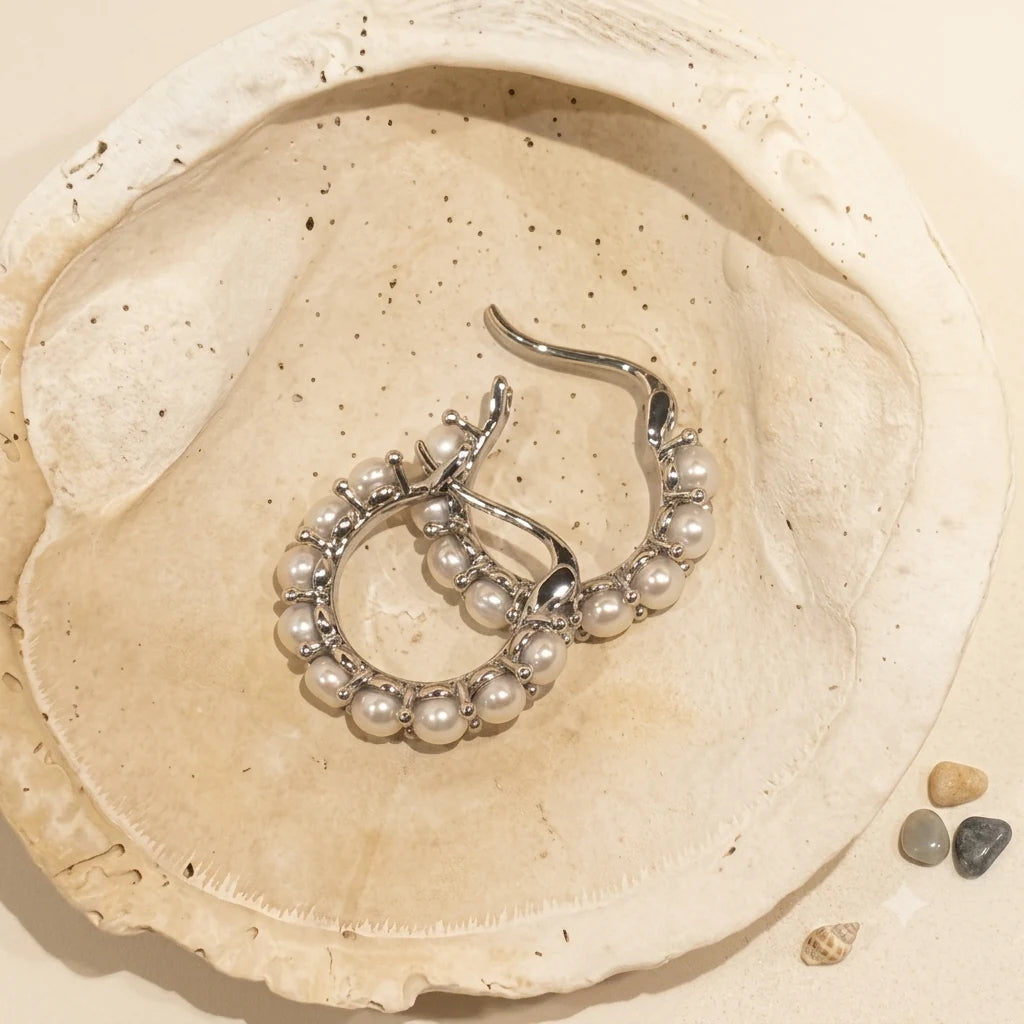 Mini Pearl Huggie Earrings in Rhodium-plated brass with 925 sterling silver posts displayed in a product styling scene.