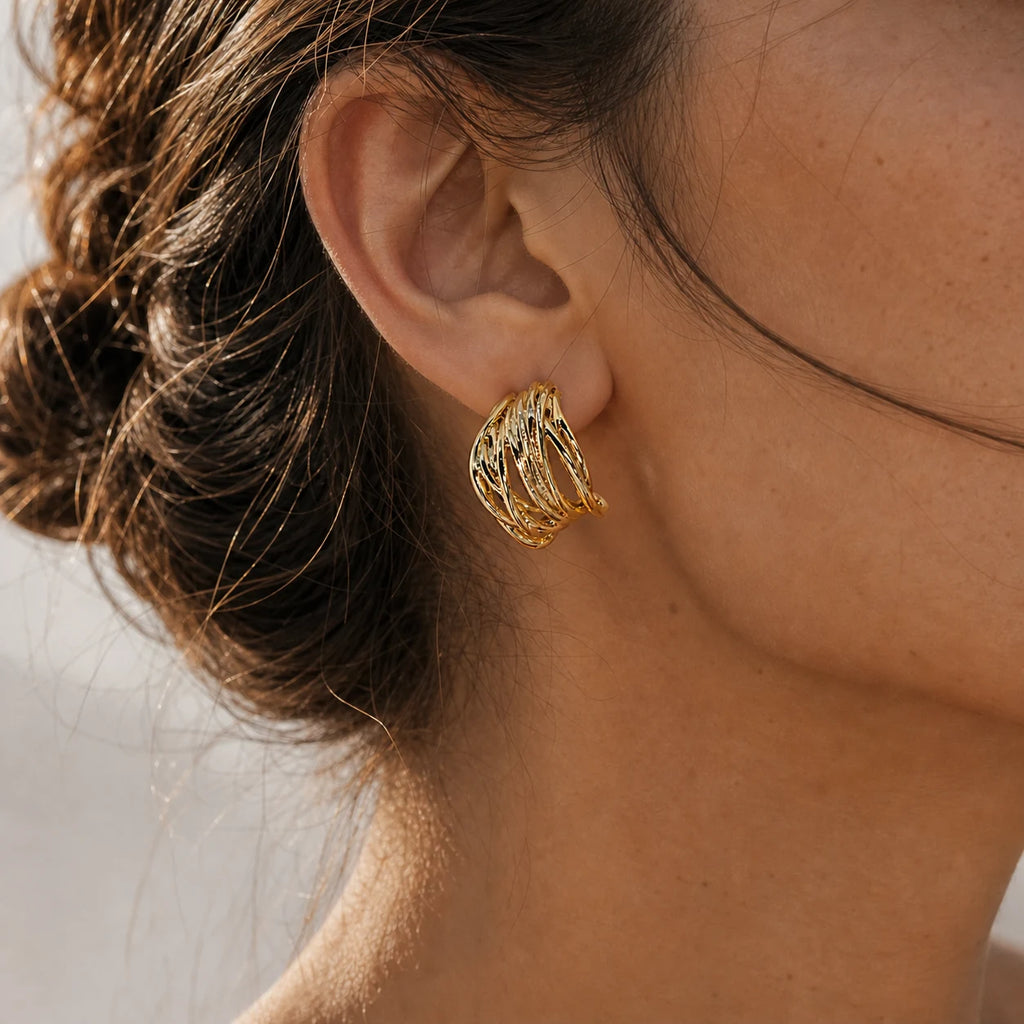 Close-up of openwork ear cuff in Gold-plated brass with 925 sterling silver hooks.