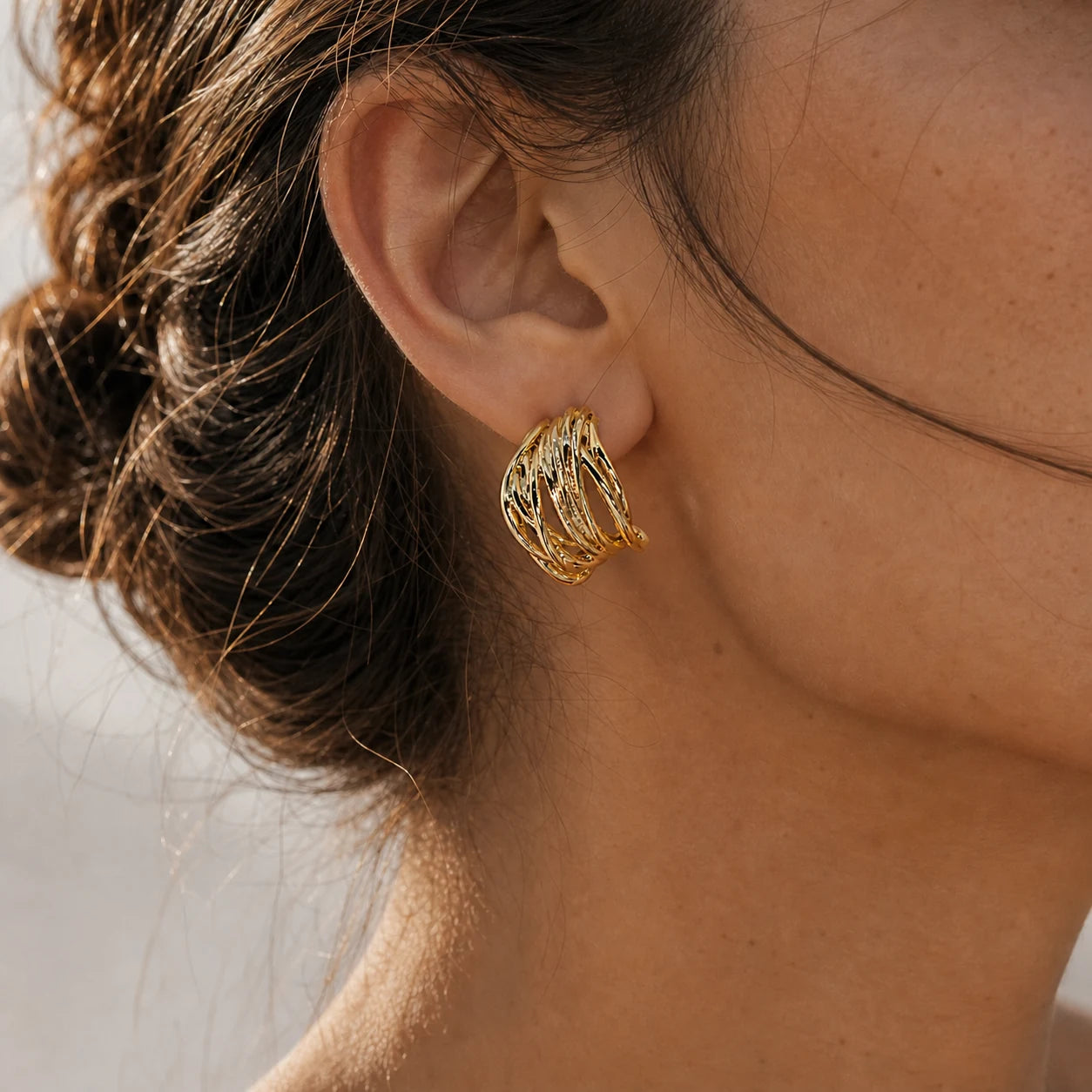 Close-up of openwork ear cuff in Gold-plated brass with 925 sterling silver hooks.