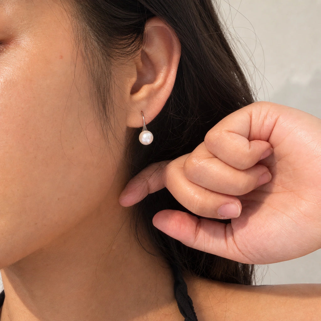 Freshwater pearl hook earrings in silver worn close-up