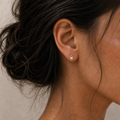 Close-up of pearl circle stud earrings in Gold-plated brass with 925 sterling silver posts.