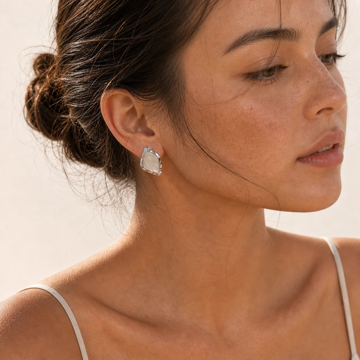 Close-up of square mother-of-pearl earrings in Rhodium-plated brass with 925 sterling silver posts.