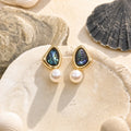 Triangle Pearl Stud Earrings in 14k gold-plated brass with 925 sterling silver posts displayed in a product styling scene.