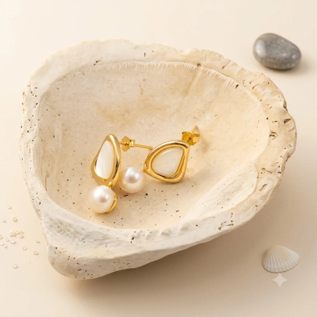 Close-up of triangle pearl stud earrings in 14k gold-plated brass with 925 sterling silver posts.