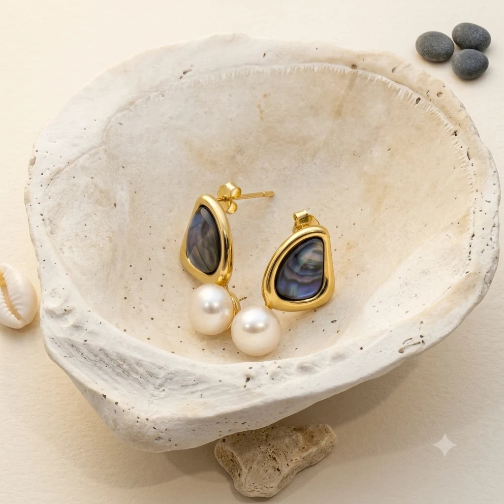 Close-up of triangle pearl stud earrings in 14k gold-plated brass with 925 sterling silver posts.