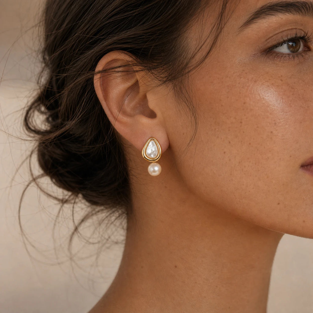 Close-up of triangle pearl stud earrings in 14k gold-plated brass with 925 sterling silver posts.