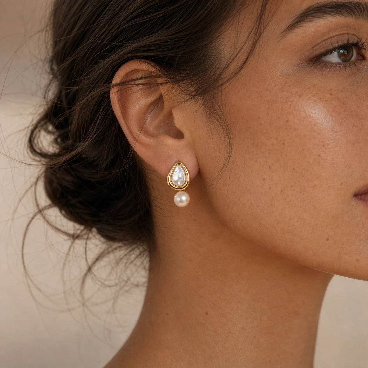 Close-up of triangle pearl stud earrings in 14k gold-plated brass with 925 sterling silver posts.