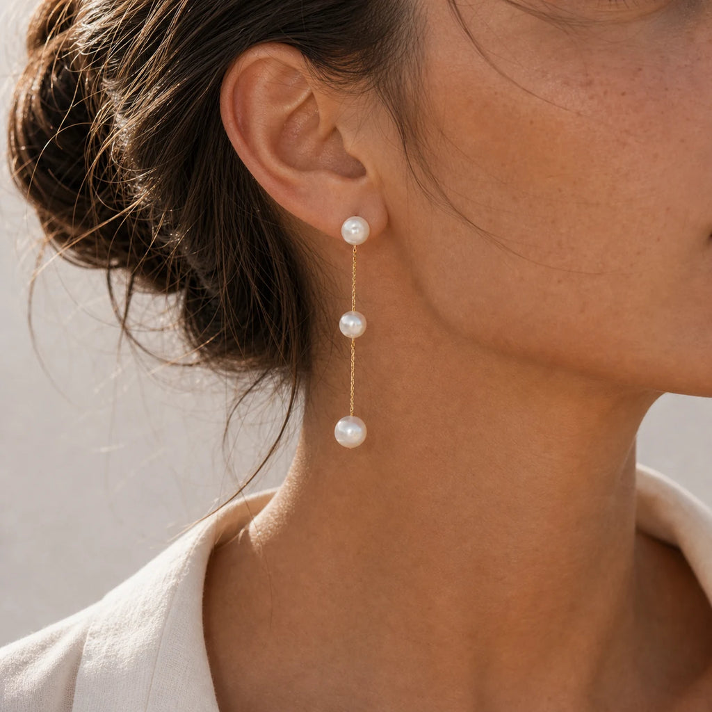Close-up of triple pearl tassel earrings in Gold-plated brass with 925 sterling silver hooks.