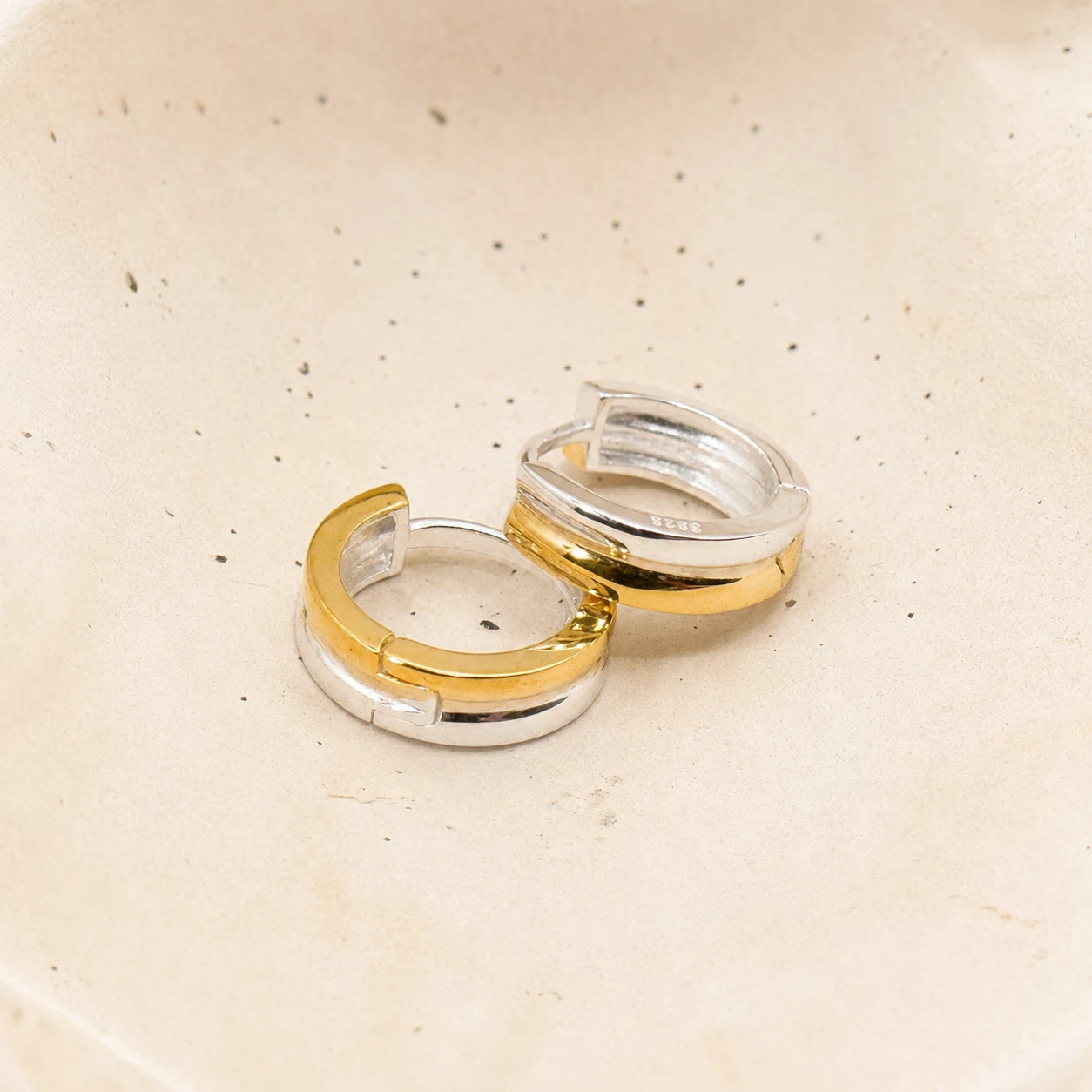 Two-Tone Hoop Earrings in Gold-plated 925 sterling silver displayed in a product styling scene.