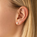 V-Shaped Pearl Stud Earrings in Gold-plated brass with 925 sterling silver posts displayed in a product styling scene.